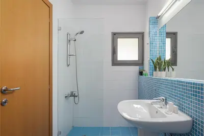 a bathroom with a sink and a shower at Grand Apollon Villa in Sounio