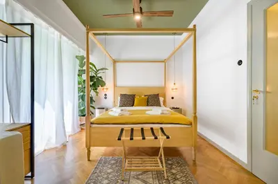 a bedroom with a four poster bed with yellow sheets at Luxurious & Stylish Kolonaki Haven in Athens