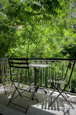 a table and chairs on a balcony with trees at Luxurious & Stylish Kolonaki Haven in Athens