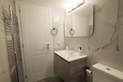 a white bathroom with a sink and a mirror at J&B Apartment in Athens