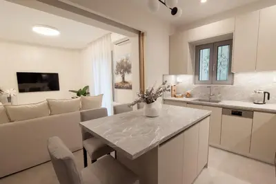a kitchen and living room with a table and a couch at J&B Apartment in Athens