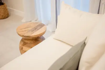 a wooden stool sitting on a couch with a pillow at J&B Apartment in Athens