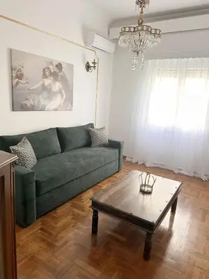 a living room with a green couch and a coffee table at Check Point - Acropolis Retro in Athens