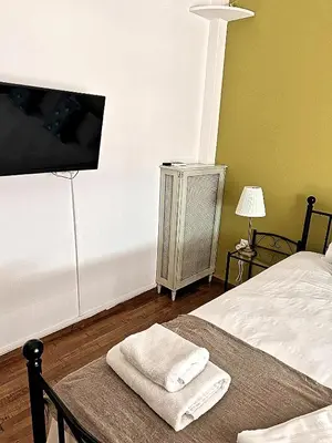 a bedroom with a bed and a flat screen tv at Check Point - Acropolis Retro in Athens