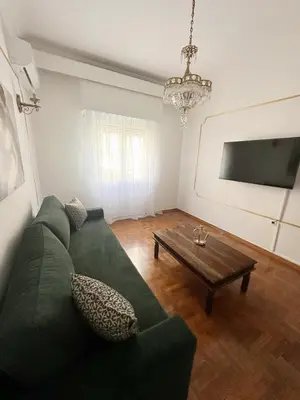 a living room with a green couch and a table at Check Point - Acropolis Retro in Athens