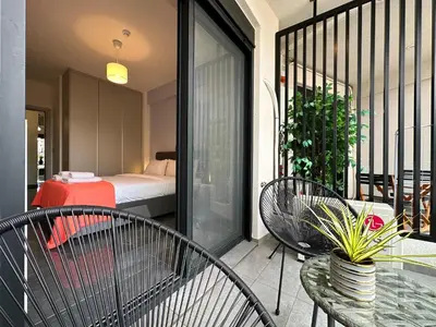a balcony with two chairs and a table and a bed at Sky Suite Apartments - Cloud9 in the City in Athens