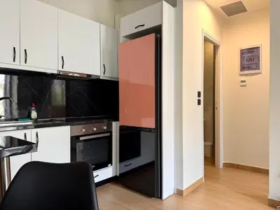 a kitchen with white cabinets and a black oven at K43 Brand-New Stylish - Cloud9 in the city in Athens