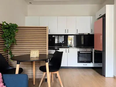 a kitchen with white cabinets and a table and chairs at K43 Brand-New Stylish - Cloud9 in the city in Athens
