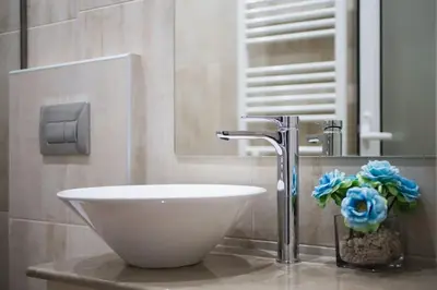 a bathroom with a sink and a vase with blue flowers at A pleasant stay near to Acropoli 1A in Athens