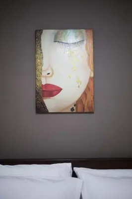 a painting of a woman on a wall above a bed at A pleasant stay near to Acropoli 1B in Athens