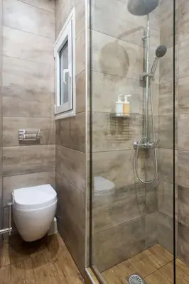a bathroom with a toilet and a glass shower at A pleasant stay near to Acropoli 1B in Athens