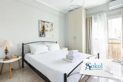 a white bedroom with a bed with a sign on it at Pleasant Apartment Near To Acropolis in Athens