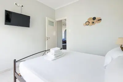 a white room with a bed and a mirror at Pleasant Apartment Near To Acropolis in Athens