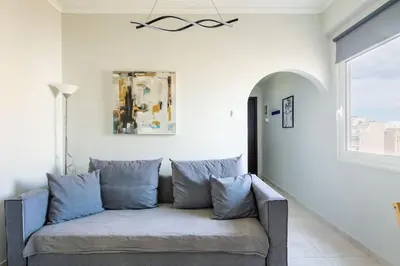 a couch in a living room with a window at Pleasant Apartment Near To Acropolis in Athens