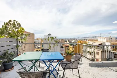 a patio with a table and chairs on a balcony at Pleasant Apartment Near To Acropolis in Athens