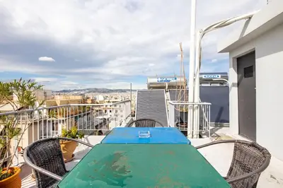 a table and chairs on a balcony with a view at Pleasant Apartment Near To Acropolis in Athens