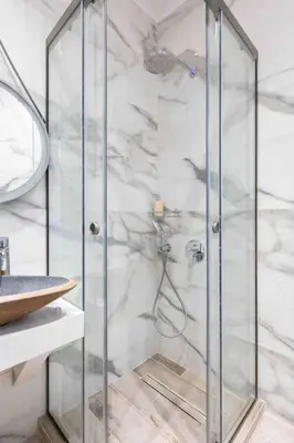 a shower with a glass door in a bathroom at Elegant studio next to Acropolis 2 in Athens
