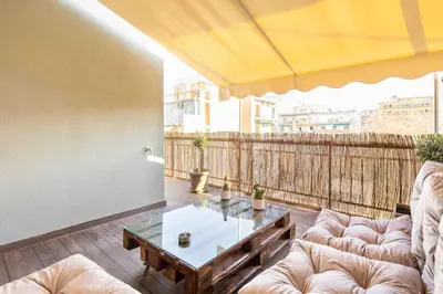 a living room with couches and a table on a balcony at Holiday close to Acropolis 1 in Athens