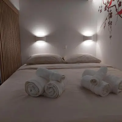 two rolls of towels on a bed in a bedroom at Lux Studio in Ilioupoli, 20 min from Acropolis in Athens