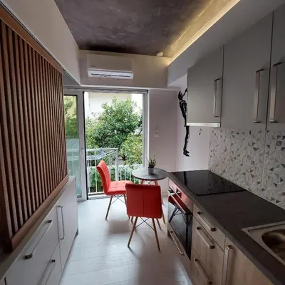 a kitchen with a table and chairs and a window at Lux Studio in Ilioupoli, 20 min from Acropolis in Athens