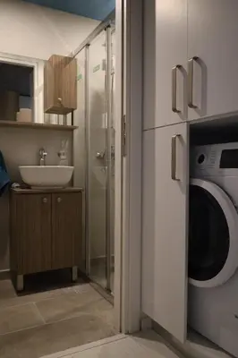 a bathroom with a sink and a washing machine at Lux Studio in Ilioupoli, 20 min from Acropolis in Athens