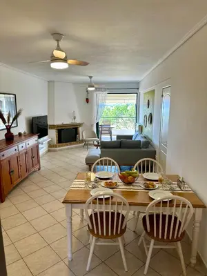 a kitchen and living room with a table and chairs at Saronida365 Sea & Sunset view in Saronida