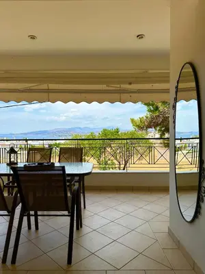 a dining room with a table and a mirror at Saronida365 Sea & Sunset view in Saronida