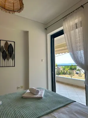 a bedroom with a bed with a view of the ocean at Saronida365 Sea & Sunset view in Saronida