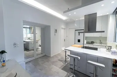 a kitchen with white cabinets and a counter with stools at Memory in Athens