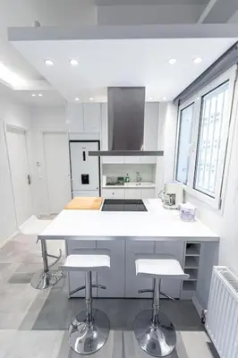 a kitchen with a white counter and two stools at Memory in Athens
