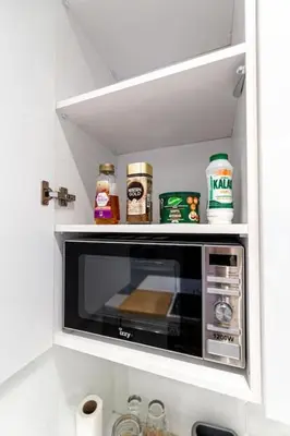 a microwave in a kitchen with spices and condiments at Memory in Athens