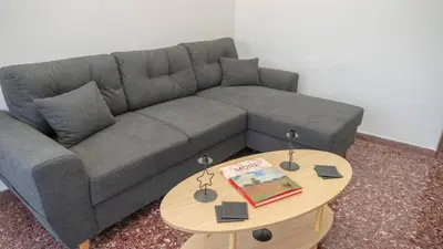 a living room with a gray couch and a table at Amazing View Of Acropolis in Athens