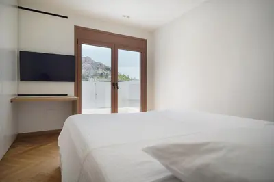 a bedroom with a white bed and a large window at Plaka House - Boutique Apartments in Athens