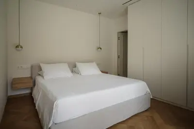 a bedroom with a large white bed with white sheets at Plaka House - Boutique Apartments in Athens
