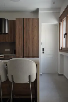 a kitchen with a table and a white door at Plaka House - Boutique Apartments in Athens