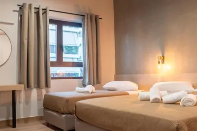 two beds in a room with a window at Athens Hawks Urban in Athens
