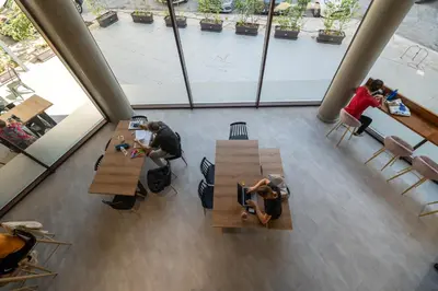 a group of people sitting at tables in a building at Athens Hawks Urban in Athens