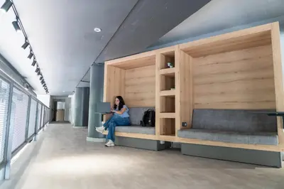 a woman sitting on a bed in a room at Athens Hawks Urban in Athens