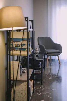 a living room with a chair and a lamp at Urban apt Metro line 3 1min walk in Athens