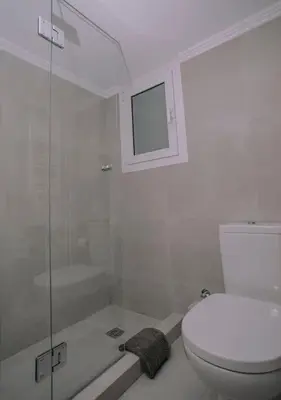 a bathroom with a toilet and a glass shower at Urban apt Metro line 3 1min walk in Athens