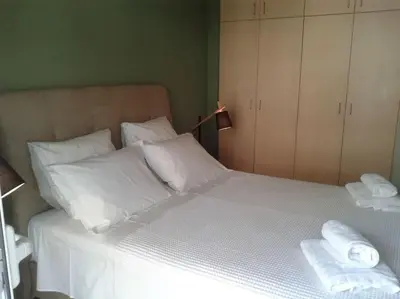 a bed with white pillows and towels on it at Urban apt Metro line 3 1min walk in Athens