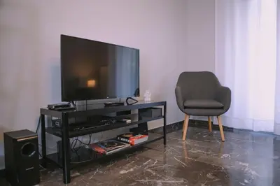 a living room with a television and a chair at Urban apt Metro line 3 1min walk in Athens