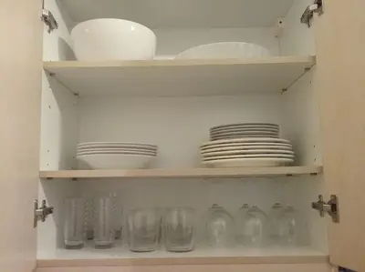 a cabinet filled with plates and glasses and dishes at Urban apt Metro line 3 1min walk in Athens