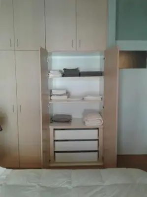 a closet with white cabinets and white towels at Urban apt Metro line 3 1min walk in Athens