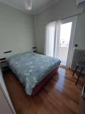 a bedroom with a bed and a large window at The sunny terrace of Athens in Athens