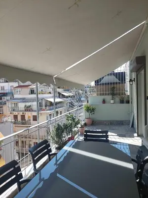a balcony with chairs and a table on a building at The sunny terrace of Athens in Athens