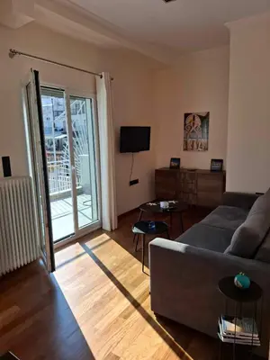 a living room with a couch and a television at The sunny terrace of Athens in Athens