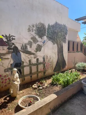 a mural of a tree on the side of a building at Medusa Apartment in Artemida