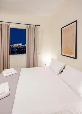 a white bedroom with a large bed and a window at S37 Acropolis View in Athens