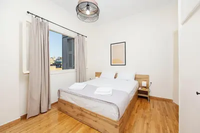 a white bedroom with a bed and a window at S37 Acropolis View in Athens